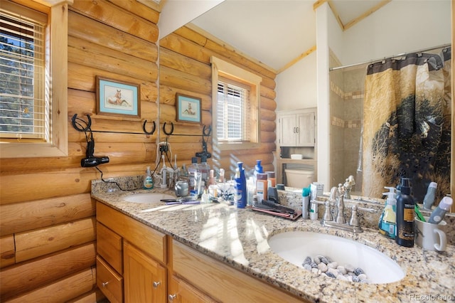 bathroom with rustic walls, vanity, vaulted ceiling, toilet, and curtained shower