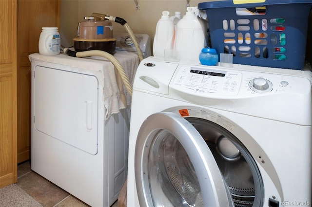 laundry area featuring light tile patterned floors and independent washer and dryer