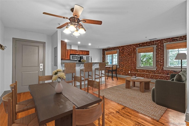 3211 Zuni St Unit 14, Denver, CO 80211 - dining space featuring brick wall, light wood-style floors, and ceiling fan