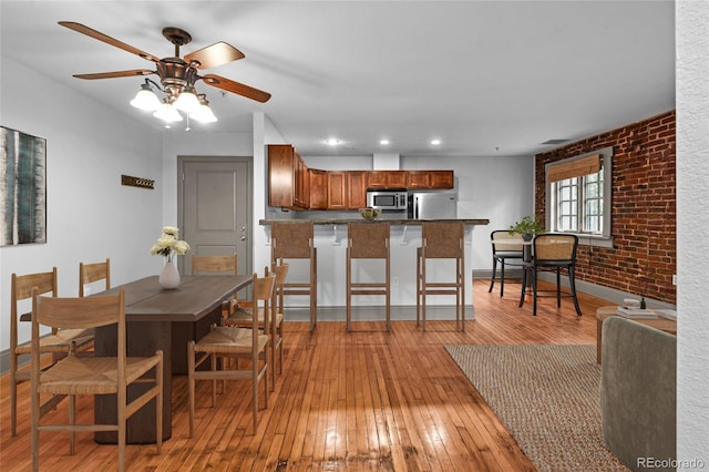 3211 Zuni St Unit 14, Denver, CO 80211 - dining room with light wood-style flooring, ceiling fan, baseboards, recessed lighting, and brick wall