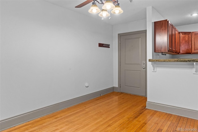 3211 Zuni St Unit 14, Denver, CO 80211 - spare room featuring light wood-style floors, ceiling fan, baseboards, and fire sprinkler in ceiling