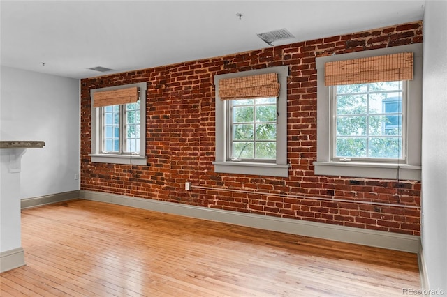 3211 Zuni St Unit 14, Denver, CO 80211 - empty room featuring baseboards, hardwood / wood-style flooring, and brick wall