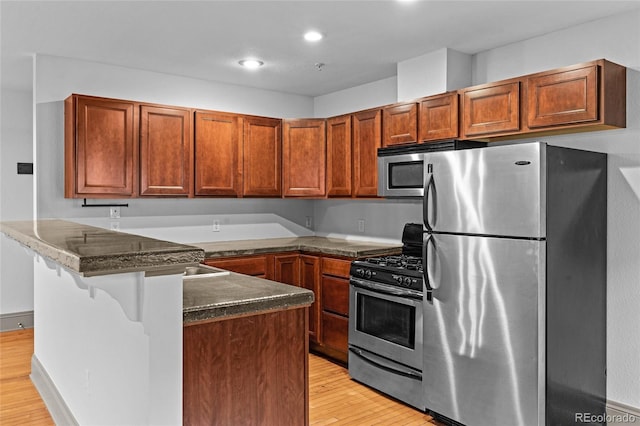 3211 Zuni St Unit 14, Denver, CO 80211 - kitchen with stainless steel appliances, light wood-type flooring, brown cabinets, a kitchen bar, and recessed lighting