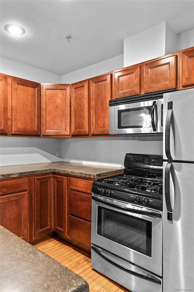 3211 Zuni St Unit 14, Denver, CO 80211 - kitchen with stainless steel appliances, light wood finished floors, and brown cabinets