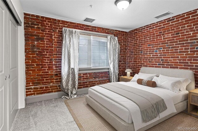 3211 Zuni St Unit 14, Denver, CO 80211 - carpeted bedroom featuring brick wall, a closet, and baseboards