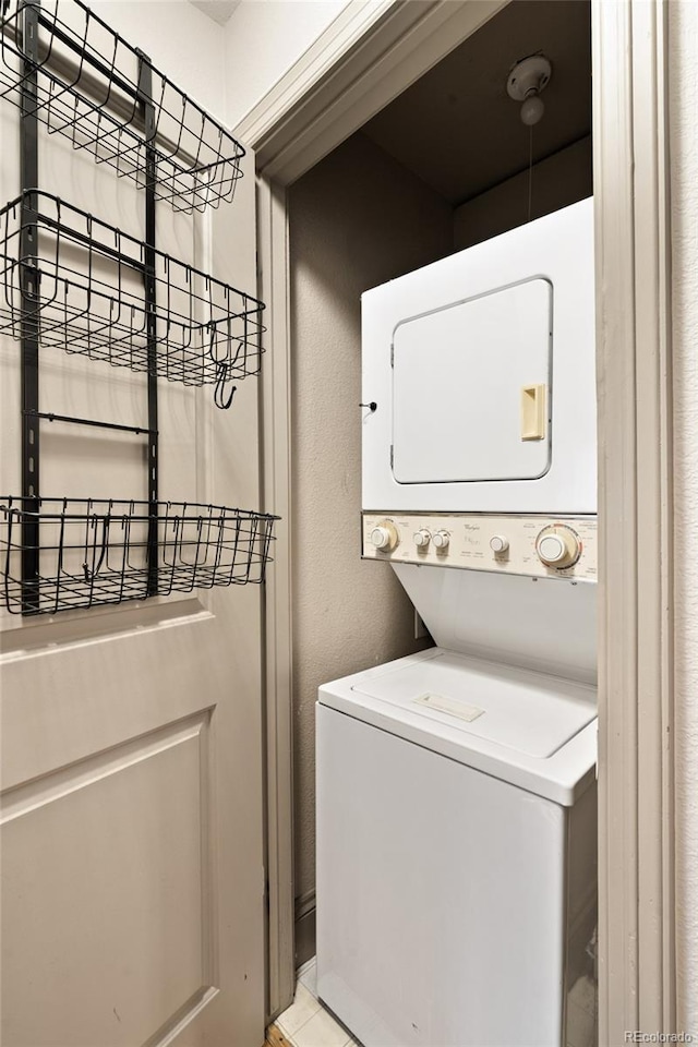 3211 Zuni St Unit 14, Denver, CO 80211 - laundry area featuring stacked washer / drying machine and a textured wall