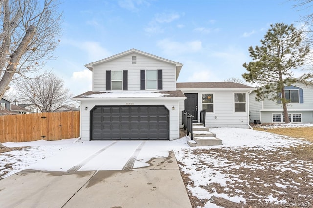 tri-level home with a garage and fence