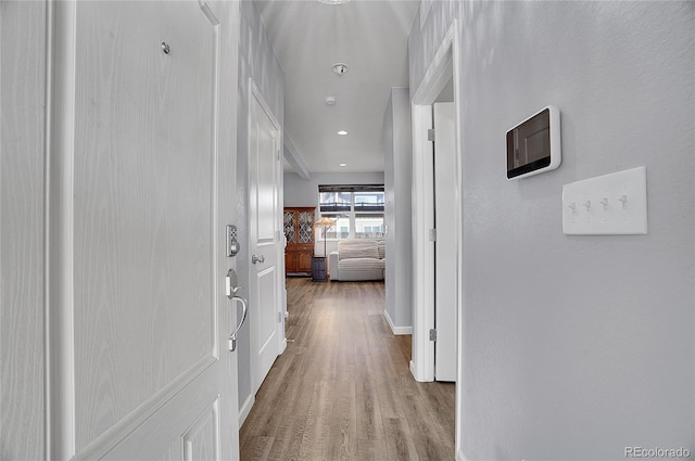 corridor with light hardwood / wood-style floors