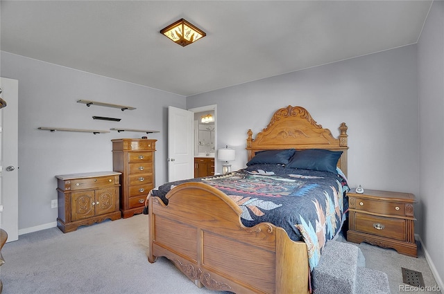 bedroom featuring light carpet and ensuite bathroom