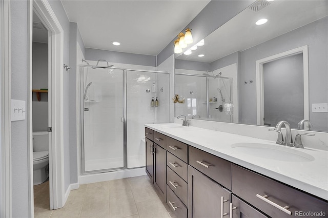 bathroom featuring vanity, toilet, an enclosed shower, and tile patterned flooring