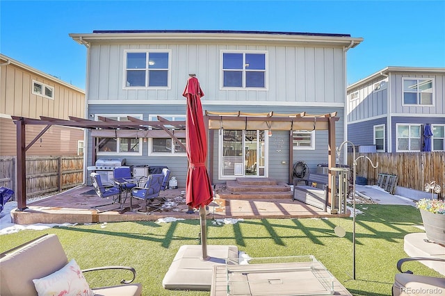 back of house featuring a pergola, a patio area, and a lawn