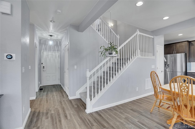 dining area featuring stairway, light wood-style flooring, and baseboards