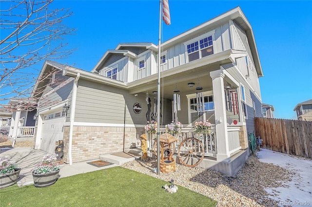 view of front of house featuring an attached garage, board and batten siding, a porch, and fence