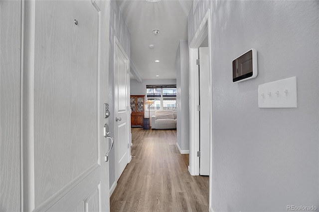 hallway with recessed lighting, baseboards, and wood finished floors