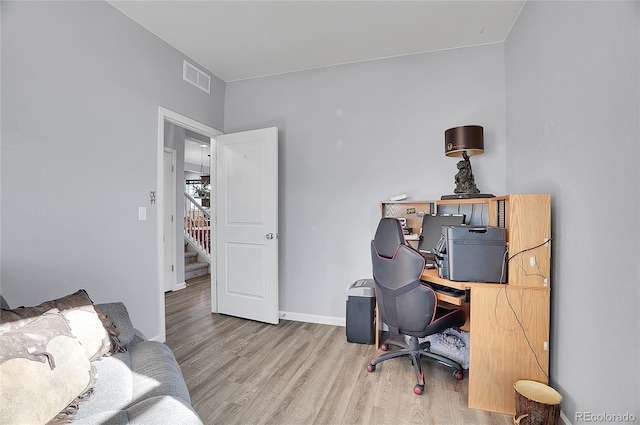 office with baseboards, visible vents, and wood finished floors