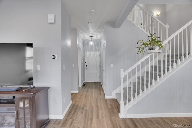 entrance foyer with baseboards, stairs, and wood finished floors