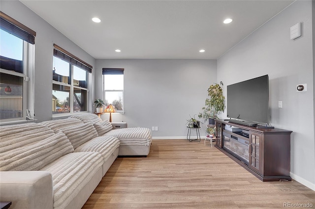 living room with light wood finished floors, baseboards, and recessed lighting