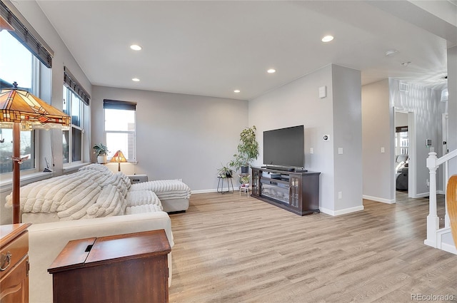 living room with recessed lighting, baseboards, and light wood finished floors