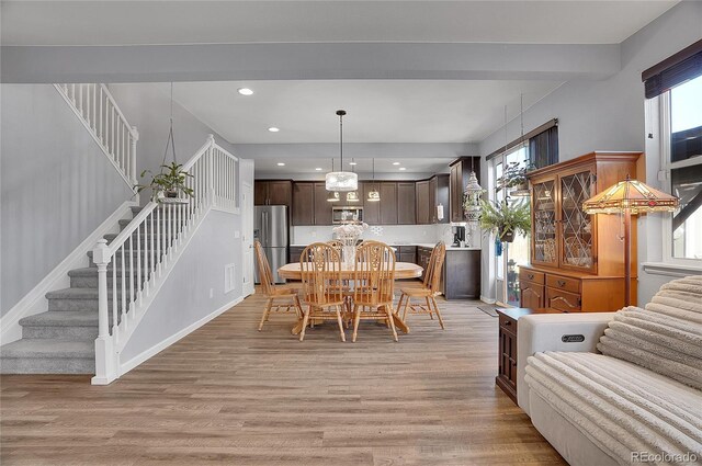 dining area with light wood-style floors, recessed lighting, visible vents, and stairway