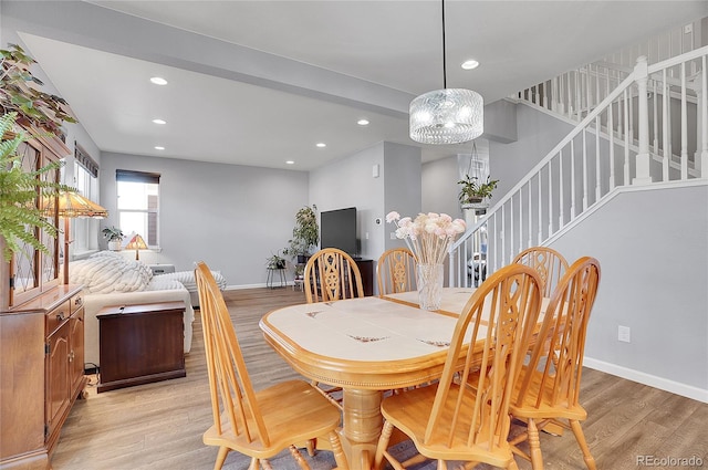 dining area with a notable chandelier, light wood finished floors, recessed lighting, baseboards, and stairway