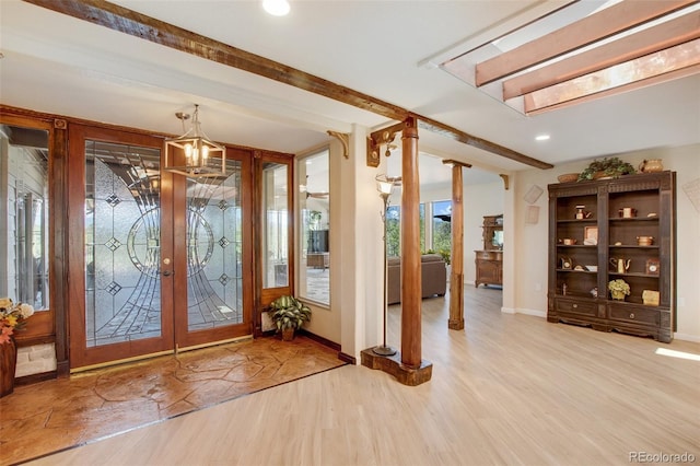 entryway with ornate columns, french doors, beamed ceiling, and light hardwood / wood-style floors