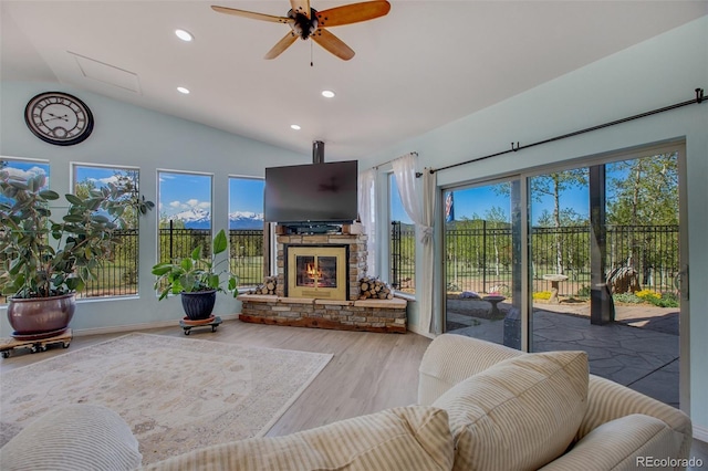 living room featuring a fireplace, hardwood / wood-style floors, ceiling fan, and lofted ceiling