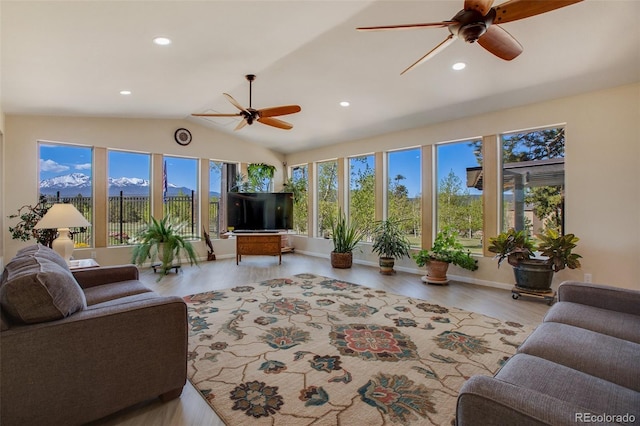 living room with ceiling fan, light wood-type flooring, and lofted ceiling