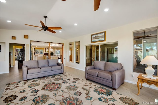 living room featuring ceiling fan, light hardwood / wood-style floors, and vaulted ceiling