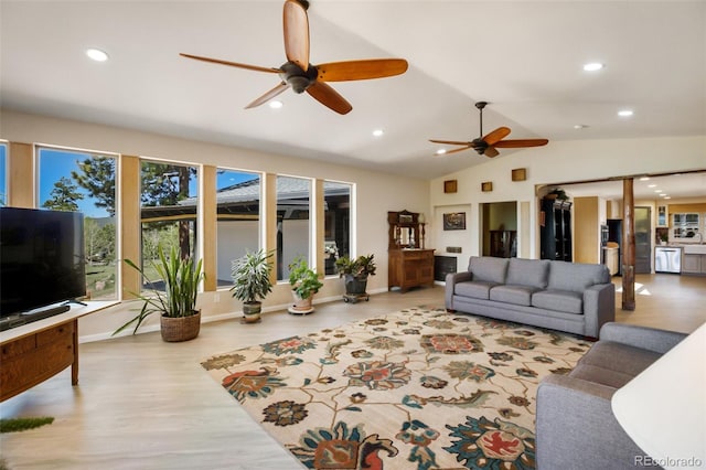 living room with a wealth of natural light, vaulted ceiling, and ceiling fan