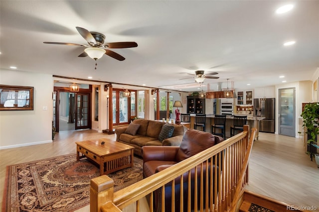 living room with ceiling fan and light wood-type flooring