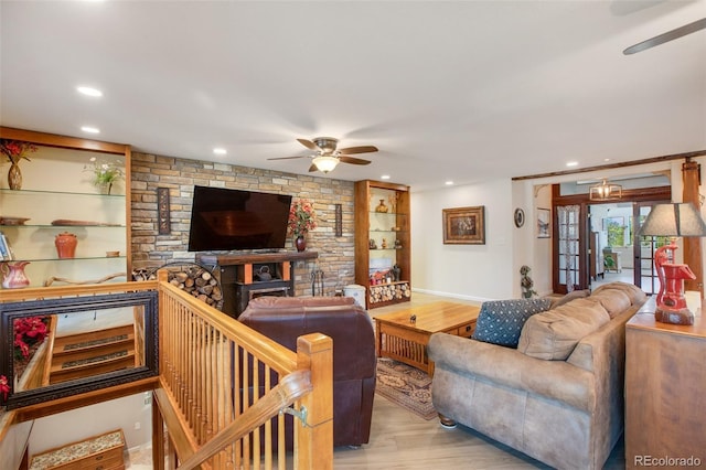 living room with ceiling fan, built in features, and light hardwood / wood-style floors