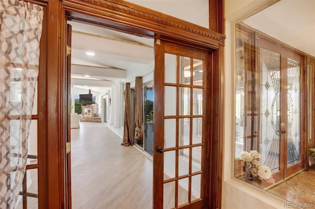 interior space with french doors, light hardwood / wood-style flooring, and lofted ceiling