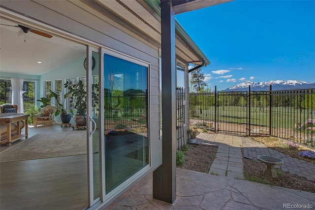 doorway with a mountain view, vaulted ceiling, and ceiling fan