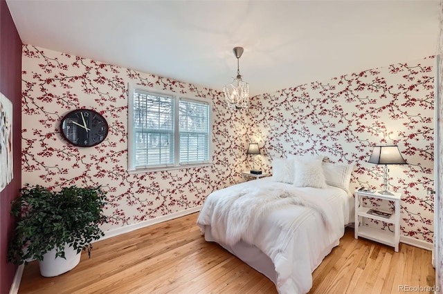 bedroom featuring light hardwood / wood-style flooring and an inviting chandelier