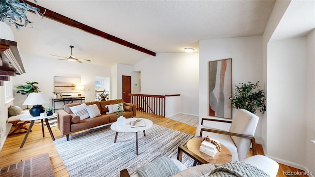 living room featuring vaulted ceiling with beams, light hardwood / wood-style floors, a textured ceiling, and ceiling fan