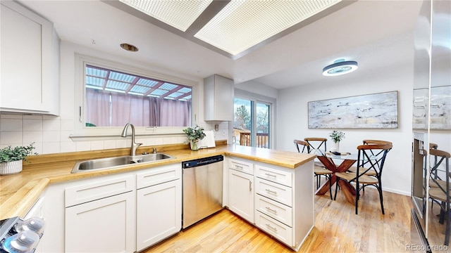 kitchen with white cabinetry, sink, kitchen peninsula, and dishwasher