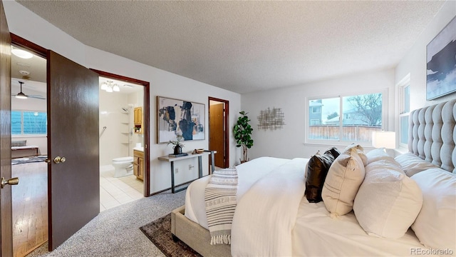 tiled bedroom with ensuite bathroom and a textured ceiling