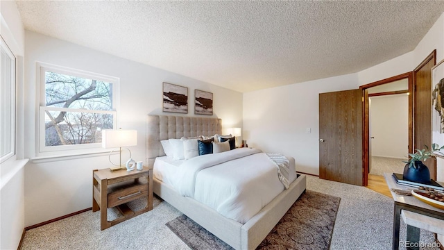 bedroom featuring light carpet and a textured ceiling