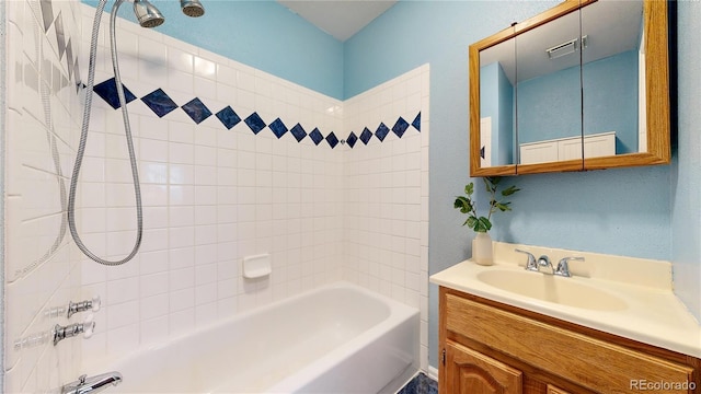 bathroom with tiled shower / bath and vanity