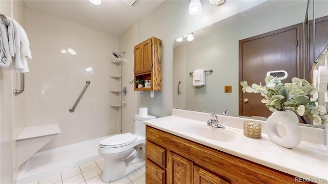 bathroom with tile patterned flooring, vanity, a shower, and toilet