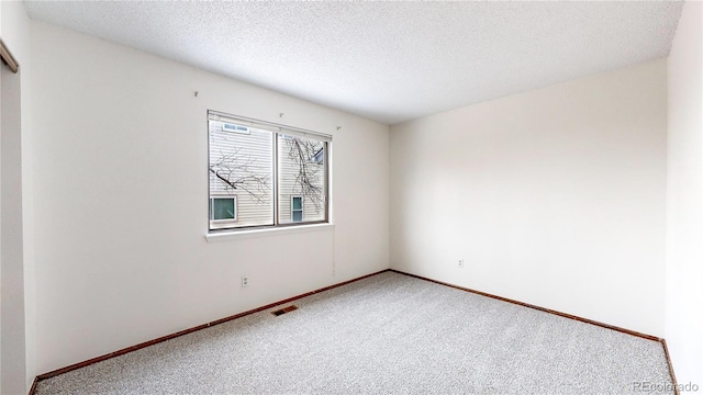 unfurnished room with carpet floors and a textured ceiling