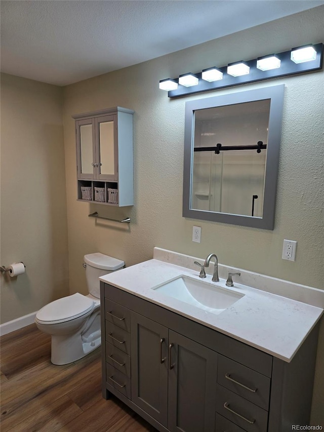 bathroom with vanity, hardwood / wood-style flooring, and toilet