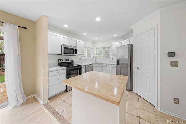 3565 W 112th Cir, Westminster, CO 80031 - kitchen with appliances with stainless steel finishes, a sink, a kitchen island, white cabinets, and crown molding