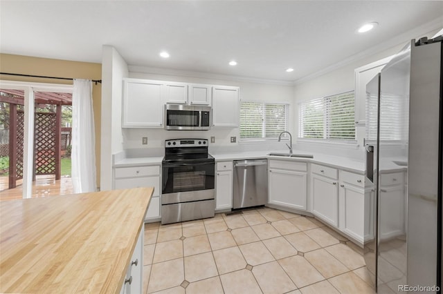 3565 W 112th Cir, Westminster, CO 80031 - kitchen with stainless steel appliances, a sink, plenty of natural light, white cabinetry, and ornamental molding