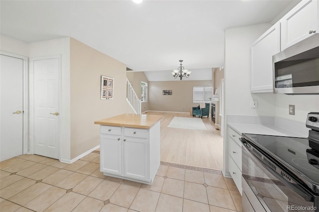 3565 W 112th Cir, Westminster, CO 80031 - kitchen featuring range with electric stovetop, stainless steel microwave, open floor plan, a chandelier, and white cabinets