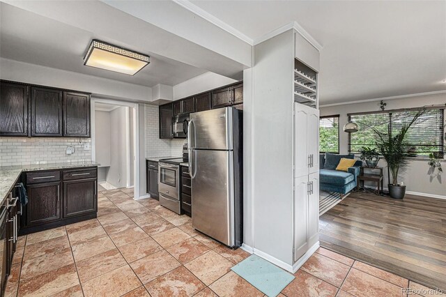120 Field St, Lakewood, CO 80226 - kitchen with stainless steel appliances, crown molding, decorative backsplash, light stone countertops, and dark brown cabinets