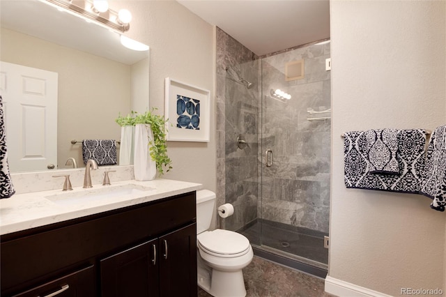 bathroom with a shower stall, toilet, and vanity