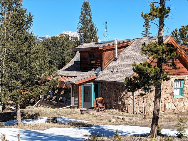 600 Rock Lake Rd, Ward, CO 80481 - view of front of property with stone siding, roof with shingles, and solar panels