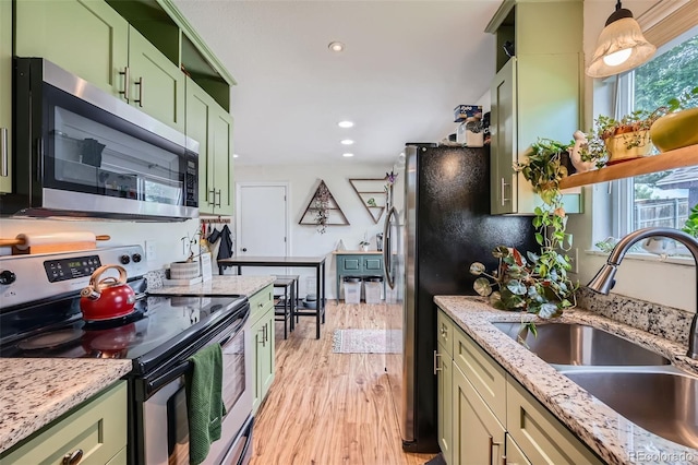 18662 E Brown Pl, Aurora, CO 80013 - kitchen with green cabinetry, appliances with stainless steel finishes, light wood-type flooring, recessed lighting, and light stone countertops