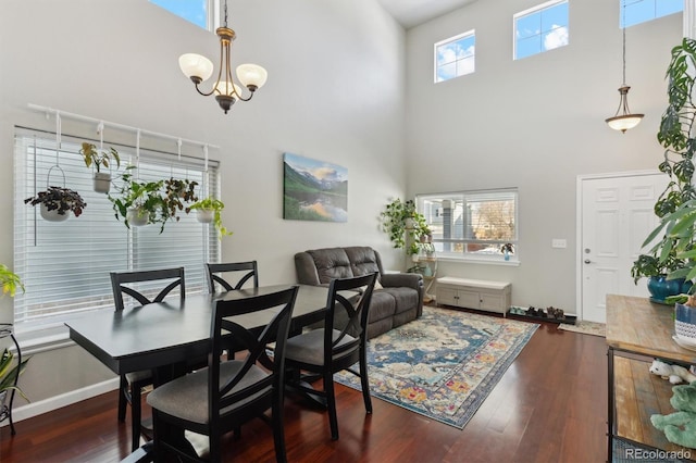 dining room with a wealth of natural light, dark hardwood / wood-style floors, and a high ceiling